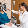 Smiling optometrist assessing patients eye sight 