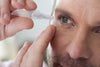 Older man applying clinitas eye drops daily dose vial to relieve his dry eyes