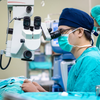 Ophthalmic surgeon performing eye surgery on patient 